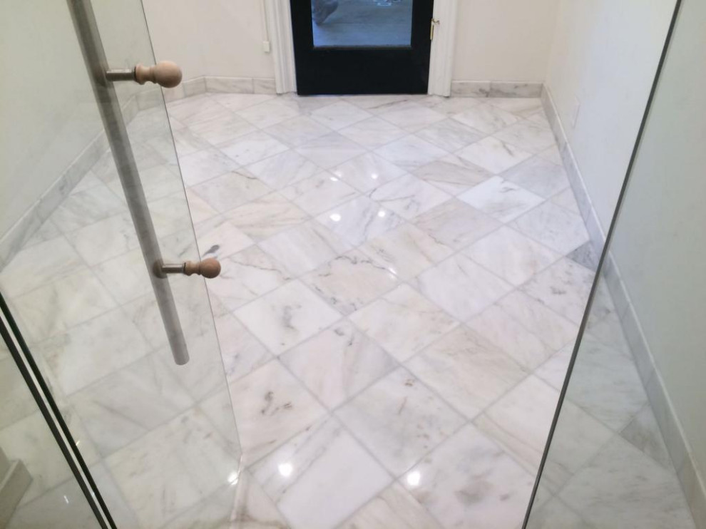 Ispirazione per una stanza da bagno padronale minimalista di medie dimensioni con ante lisce, piastrelle di marmo, pavimento in mattoni, lavabo da incasso, top in marmo e pavimento bianco