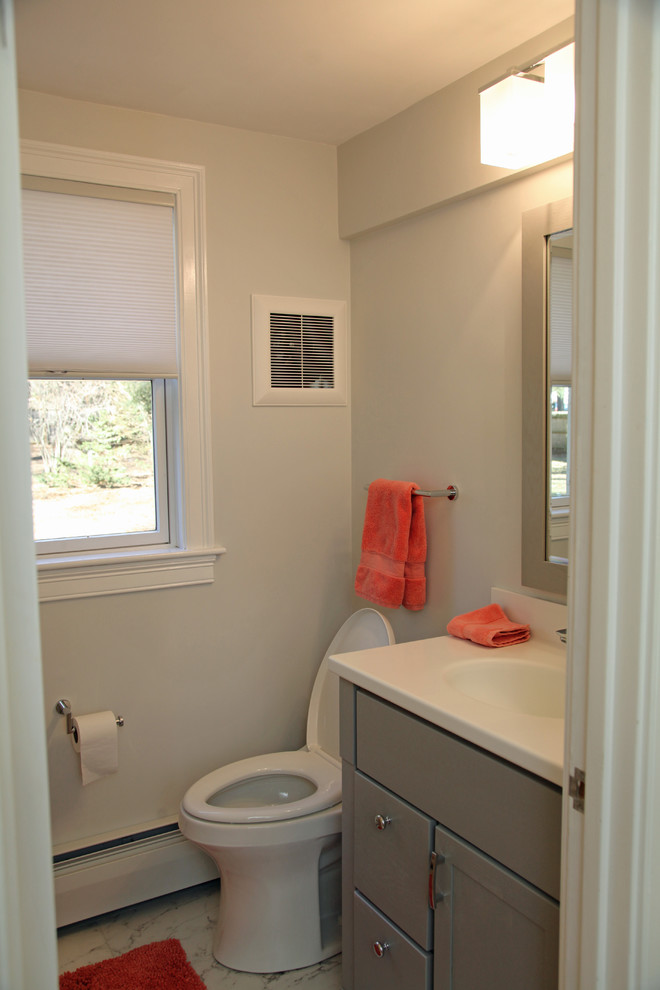 Photo of a medium sized traditional bathroom in Boston with recessed-panel cabinets, grey cabinets, an alcove bath, a shower/bath combination, a one-piece toilet, grey walls, ceramic flooring, an integrated sink, solid surface worktops, grey floors and a shower curtain.