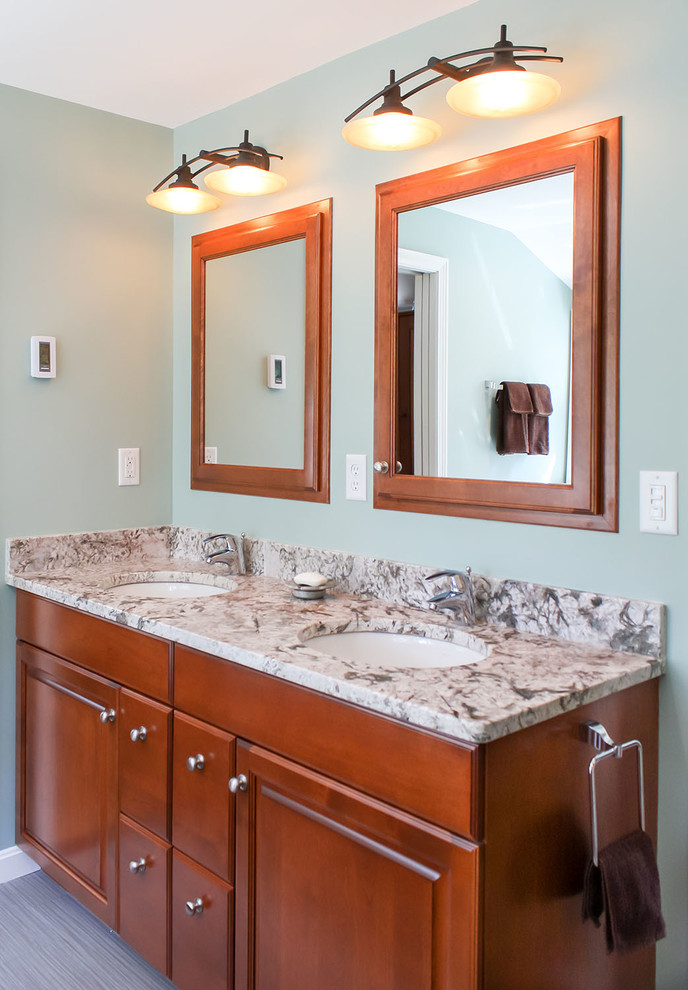 Inredning av ett klassiskt badrum, med ett undermonterad handfat, luckor med upphöjd panel, skåp i mellenmörkt trä, granitbänkskiva, ett platsbyggt badkar och en dusch i en alkov