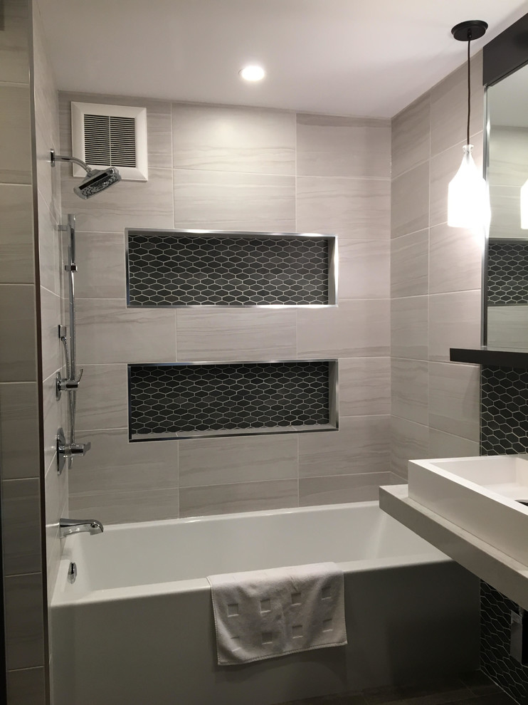 Modern inredning av ett mellanstort en-suite badrum, med skåp i mörkt trä, ett badkar i en alkov, en dusch/badkar-kombination, svart och vit kakel, glasskiva, vita väggar, klinkergolv i porslin, ett fristående handfat och bänkskiva i kvarts