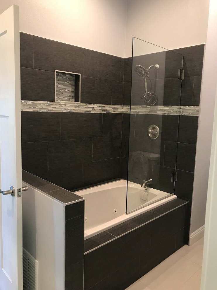 Exemple d'une salle de bain principale tendance de taille moyenne avec une baignoire d'angle, un combiné douche/baignoire, un carrelage noir, un mur gris, un sol en marbre, un sol gris et une cabine de douche à porte battante.