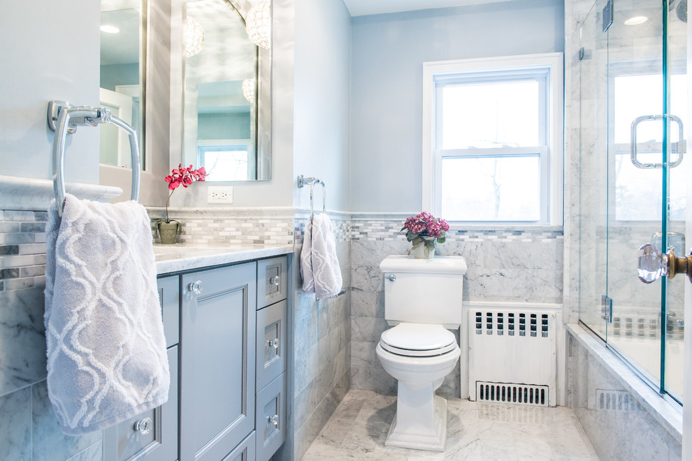 Exemple d'une salle de bain chic de taille moyenne avec un placard avec porte à panneau encastré, une baignoire encastrée, un combiné douche/baignoire, WC séparés, un carrelage bleu, des carreaux de porcelaine, un mur bleu, un lavabo encastré, un plan de toilette en quartz modifié, un sol gris et aucune cabine.