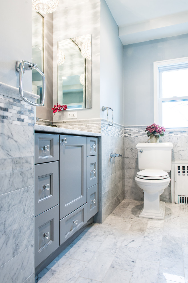 Klassisk inredning av ett mellanstort badrum, med luckor med infälld panel, ett undermonterat badkar, en dusch/badkar-kombination, en toalettstol med separat cisternkåpa, blå kakel, porslinskakel, blå väggar, ett undermonterad handfat, bänkskiva i kvarts, grått golv och med dusch som är öppen