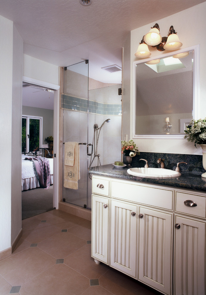 Idee per una stanza da bagno padronale chic di medie dimensioni con lavabo da incasso, consolle stile comò, ante bianche, top in granito, doccia ad angolo e pareti bianche