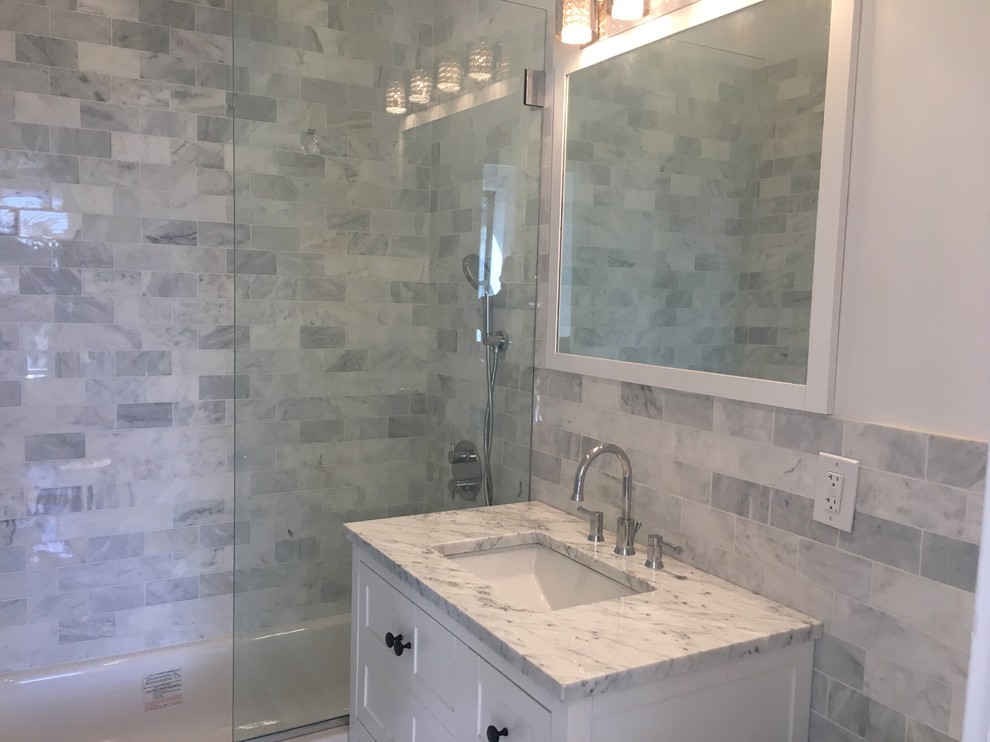Пример оригинального дизайна: главная ванная комната среднего размера в современном стиле с белыми фасадами, душем в нише, унитазом-моноблоком, белой плиткой, керамической плиткой, белыми стенами, полом из керамической плитки, накладной раковиной и мраморной столешницей