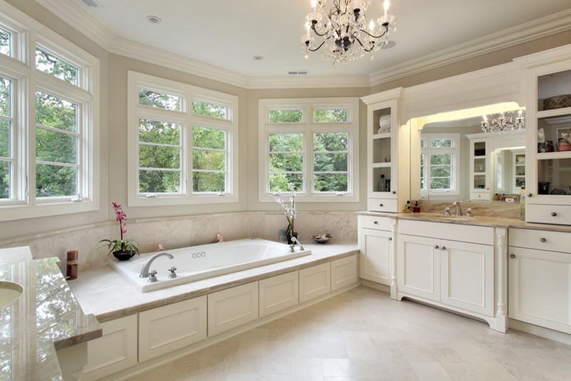Inredning av ett klassiskt stort en-suite badrum, med luckor med infälld panel, vita skåp, ett platsbyggt badkar, beige kakel, beige väggar, kalkstensgolv och ett undermonterad handfat