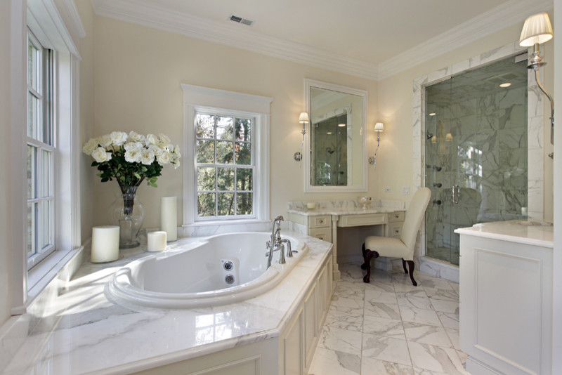 Exemple d'une douche en alcôve principale chic de taille moyenne avec un placard avec porte à panneau encastré, des portes de placard blanches, une baignoire posée, un carrelage de pierre, un mur beige, un sol en marbre et un plan de toilette en marbre.