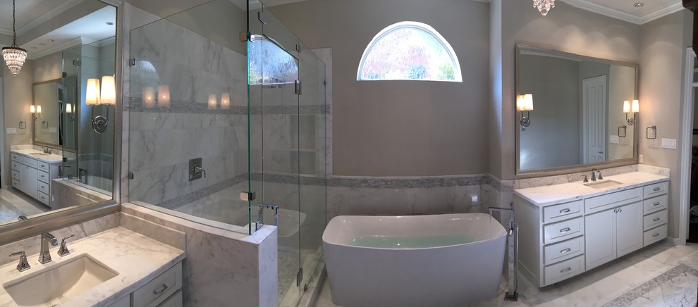 Inredning av ett modernt stort en-suite badrum, med ett undermonterad handfat, skåp i shakerstil, vita skåp, marmorbänkskiva, ett fristående badkar, en hörndusch, en toalettstol med hel cisternkåpa, vit kakel, stenkakel, vita väggar och marmorgolv