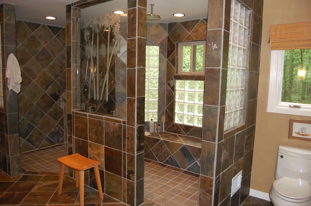 Inspiration for a large ceramic tile and brown floor corner shower remodel in Houston with a one-piece toilet and brown walls