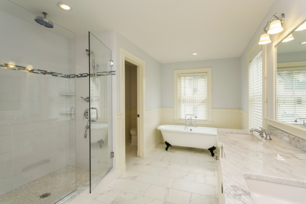Photo of a medium sized beach style ensuite bathroom in Los Angeles with freestanding cabinets, white cabinets, a freestanding bath, an alcove shower, a one-piece toilet, blue tiles, blue walls, marble flooring, a built-in sink, quartz worktops, white floors, a hinged door and white worktops.
