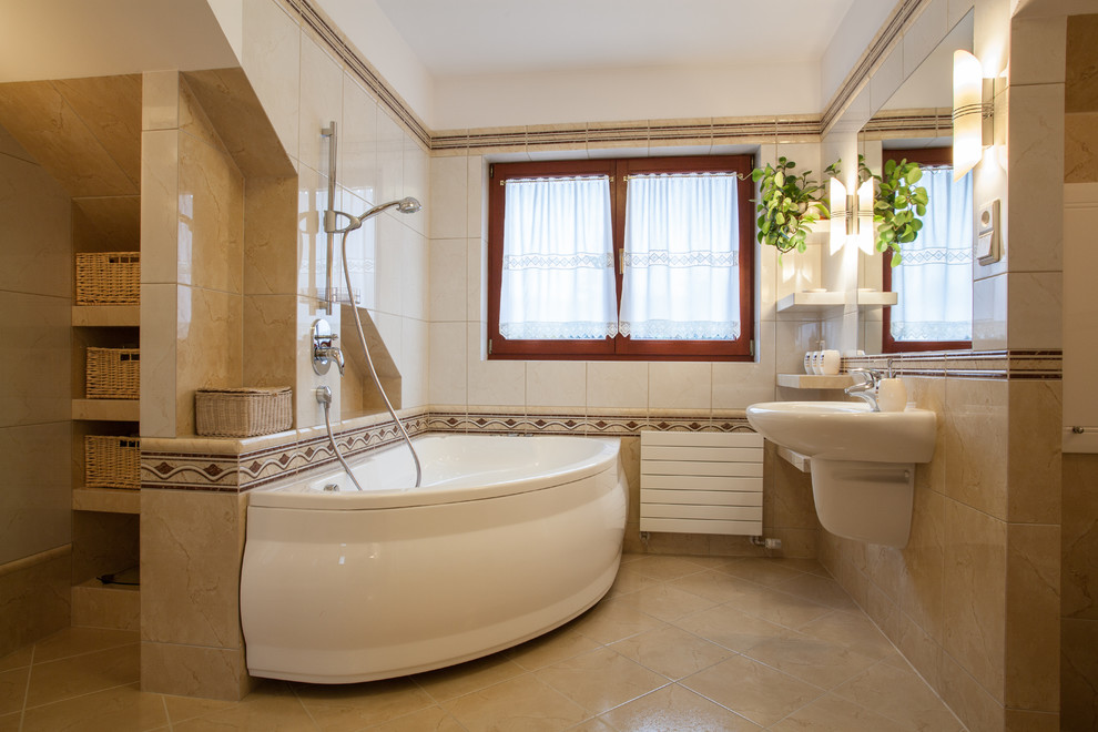 Inspiration för mellanstora moderna en-suite badrum, med ett hörnbadkar, en dusch/badkar-kombination, beige kakel, kakel i småsten, beige väggar, skiffergolv och ett väggmonterat handfat