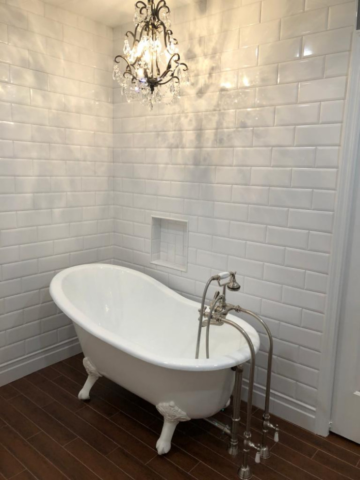 Diseño de cuarto de baño principal clásico pequeño con puertas de armario blancas, bañera exenta, baldosas y/o azulejos blancos, baldosas y/o azulejos de cerámica, paredes blancas, lavabo con pedestal y suelo marrón