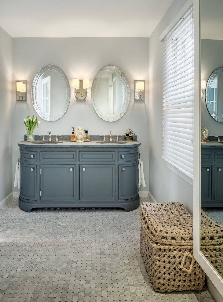 Imagen de cuarto de baño principal clásico de tamaño medio con lavabo bajoencimera, encimera de mármol, paredes grises, suelo con mosaicos de baldosas, puertas de armario azules y armarios con paneles empotrados