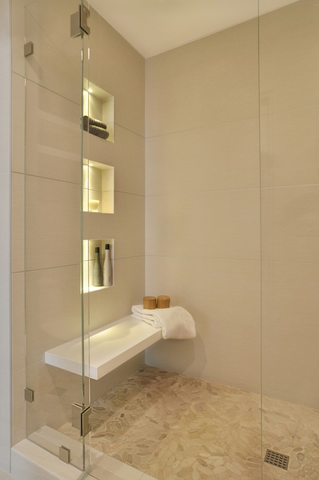 Exemple d'une grande douche en alcôve principale chic avec un carrelage beige, des carreaux de porcelaine, un mur beige, un sol beige et une cabine de douche à porte battante.