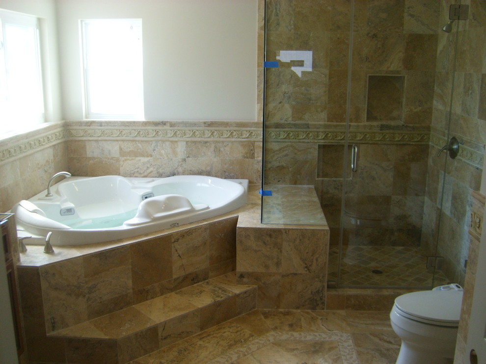 Großes Mediterranes Badezimmer En Suite mit Eckbadewanne, Eckdusche, beigen Fliesen, Porzellanfliesen, beiger Wandfarbe, braunem Boden und Falttür-Duschabtrennung in Orange County