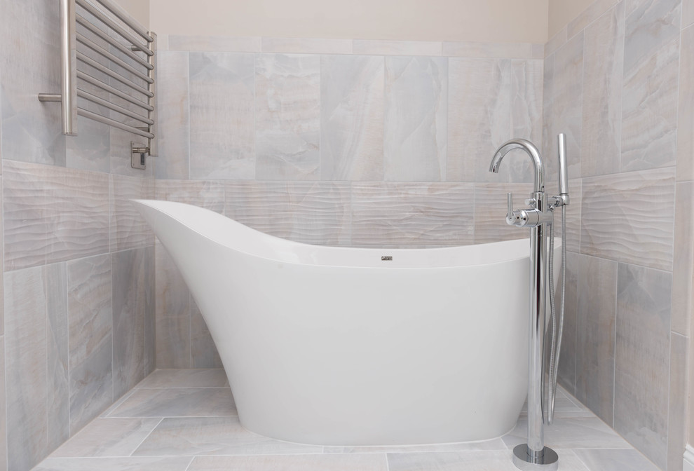 Idee per una stanza da bagno padronale contemporanea con vasca freestanding, piastrelle beige, piastrelle in pietra e pareti beige