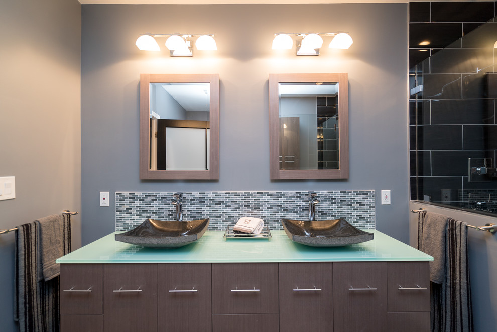 Inspiration for a mid-sized contemporary master black tile, gray tile and mosaic tile alcove shower remodel in Baltimore with flat-panel cabinets, brown cabinets, gray walls, a vessel sink and glass countertops