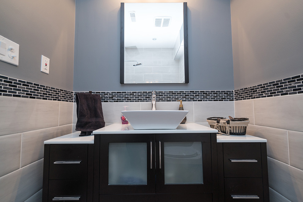 Réalisation d'une salle d'eau design de taille moyenne avec un placard à porte plane, des portes de placard noires, un carrelage noir, un carrelage gris, mosaïque, un mur gris, une vasque et un plan de toilette en quartz modifié.
