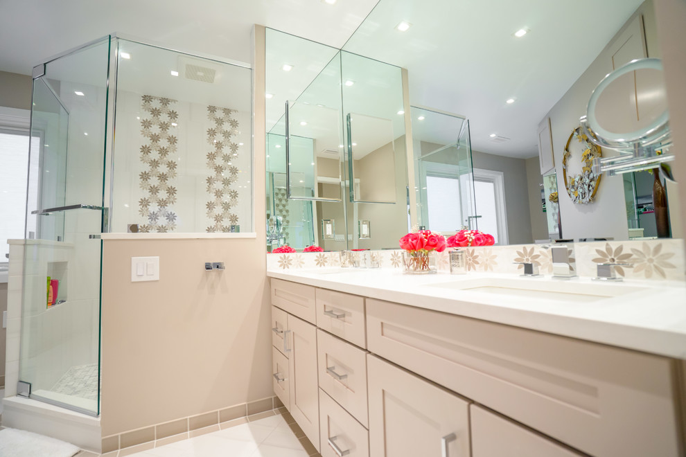 На фото: большая главная ванная комната в стиле модернизм с плоскими фасадами, белыми фасадами, угловым душем, разноцветной плиткой, бежевыми стенами, врезной раковиной, столешницей из кварцита и белым полом