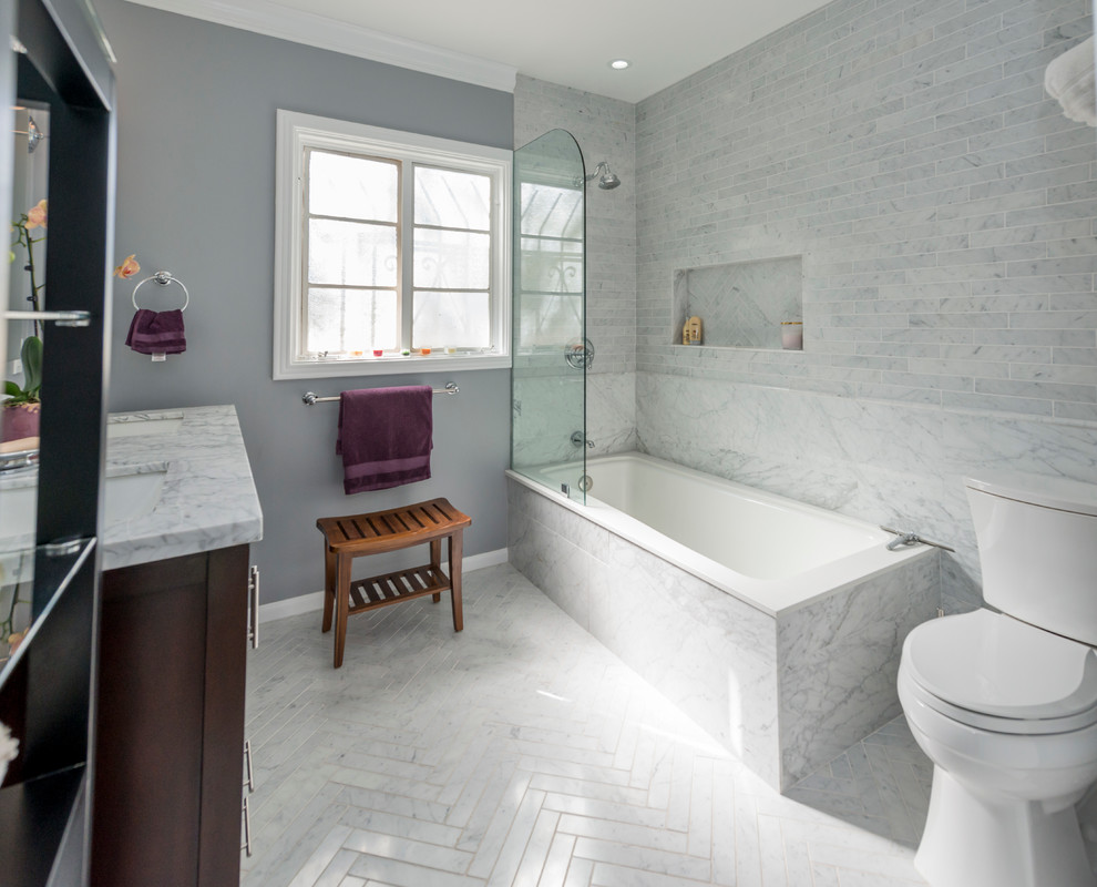 Exemple d'une salle de bain principale chic en bois foncé de taille moyenne avec un placard en trompe-l'oeil, une baignoire en alcôve, un combiné douche/baignoire, un carrelage blanc, du carrelage en marbre, un mur gris, un sol en marbre, un lavabo encastré, un plan de toilette en marbre, un sol blanc et un plan de toilette blanc.