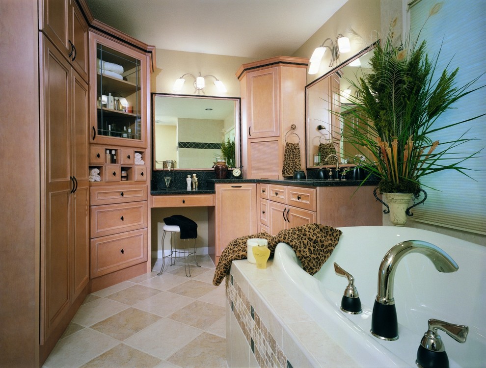 Foto på ett mellanstort vintage en-suite badrum, med luckor med infälld panel, skåp i ljust trä, ett hörnbadkar, beige kakel, porslinskakel, beige väggar, klinkergolv i porslin, ett fristående handfat och granitbänkskiva