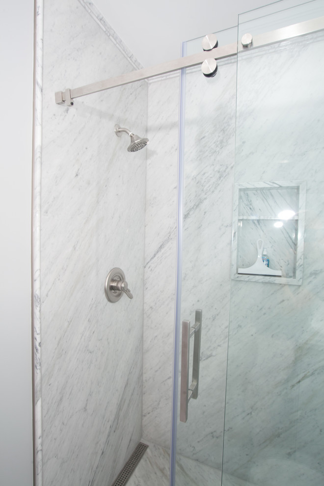 Klassisk inredning av ett mellanstort vit vitt en-suite badrum, med luckor med upphöjd panel, grå skåp, en dusch i en alkov, en toalettstol med separat cisternkåpa, flerfärgad kakel, stenhäll, blå väggar, marmorgolv, ett integrerad handfat, bänkskiva i akrylsten, flerfärgat golv och dusch med skjutdörr