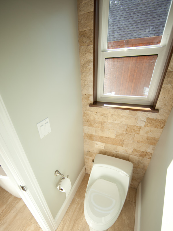 Réalisation d'une grande salle de bain design avec WC à poser, un carrelage beige, un sol en travertin, un mur gris et un sol beige.