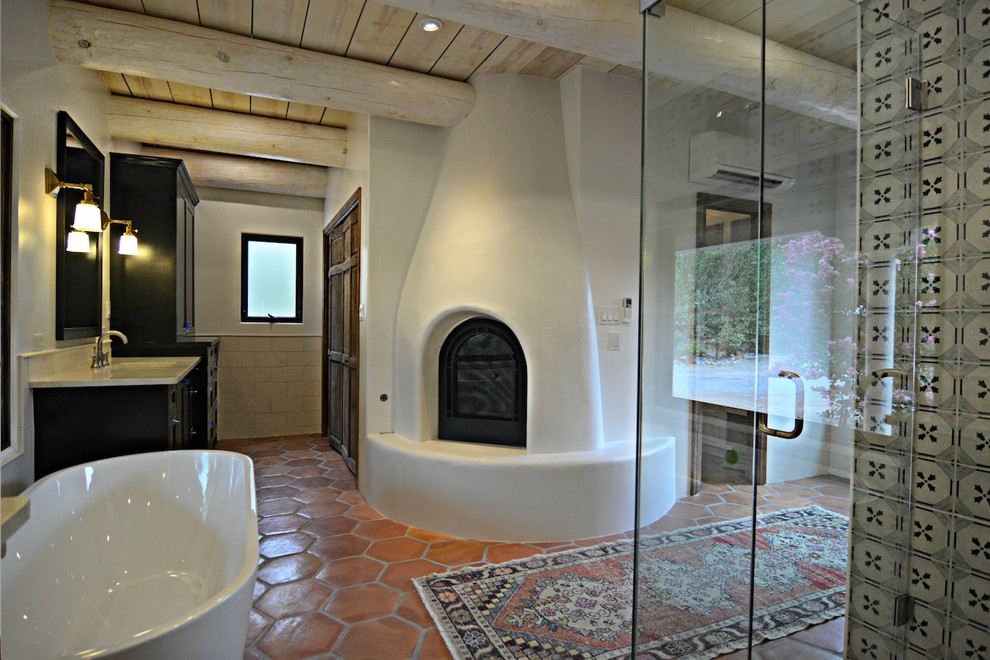 На фото: ванная комната в стиле фьюжн с отдельно стоящей ванной, белыми стенами, полом из терракотовой плитки, столешницей из кварцита и коричневым полом с