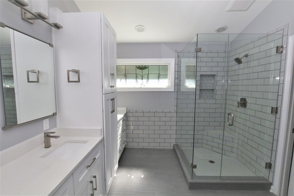 Inspiration for a medium sized modern ensuite bathroom in Atlanta with shaker cabinets, white cabinets, a corner shower, grey tiles, cement tiles, grey walls, a submerged sink, engineered stone worktops, grey floors, a hinged door and white worktops.