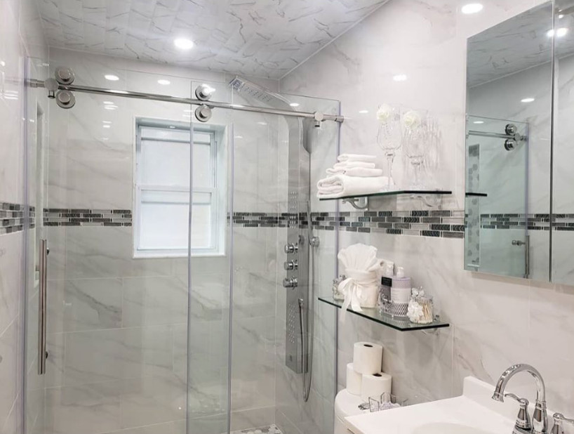 Exempel på ett mellanstort modernt vit vitt badrum med dusch, med luckor med upphöjd panel, vita skåp, en dusch i en alkov, en toalettstol med separat cisternkåpa, grå kakel, marmorkakel, grå väggar, ett integrerad handfat och dusch med skjutdörr