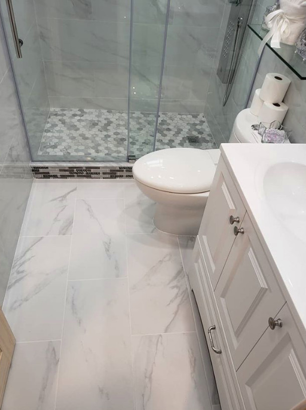 Inspiration for a medium sized contemporary shower room bathroom in New York with raised-panel cabinets, white cabinets, an alcove shower, a two-piece toilet, grey tiles, marble tiles, grey walls, an integrated sink, a sliding door, white worktops, a single sink and a built in vanity unit.