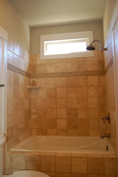 アトランタにある中くらいなトラディショナルスタイルのおしゃれなマスターバスルーム (置き型浴槽、シャワー付き浴槽	、マルチカラーのタイル、石タイル、ベージュの壁、ライムストーンの床) の写真