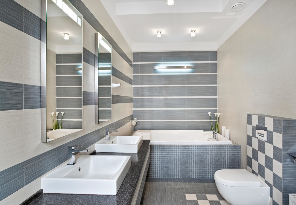 Inredning av ett modernt mellanstort svart svart en-suite badrum, med grå skåp, en jacuzzi, en vägghängd toalettstol, flerfärgad kakel, porslinskakel, grå väggar, klinkergolv i porslin, granitbänkskiva, grått golv och med dusch som är öppen