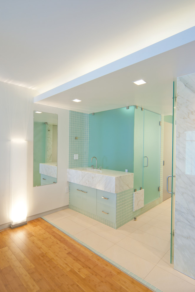 Exempel på ett stort modernt badrum med dusch, med släta luckor, blå skåp, en dusch i en alkov, blå kakel, porslinskakel, vita väggar, klinkergolv i porslin, ett undermonterad handfat och marmorbänkskiva