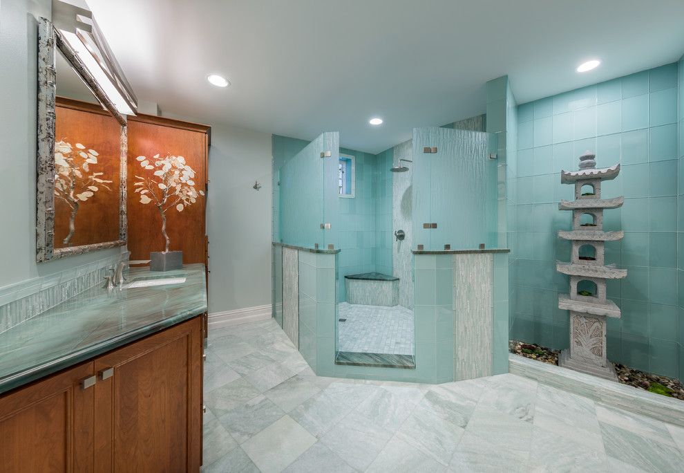 На фото: большая главная ванная комната в восточном стиле с фасадами с декоративным кантом, фасадами цвета дерева среднего тона, открытым душем, синей плиткой, стеклянной плиткой, синими стенами, полом из керамогранита, врезной раковиной и столешницей из плитки с