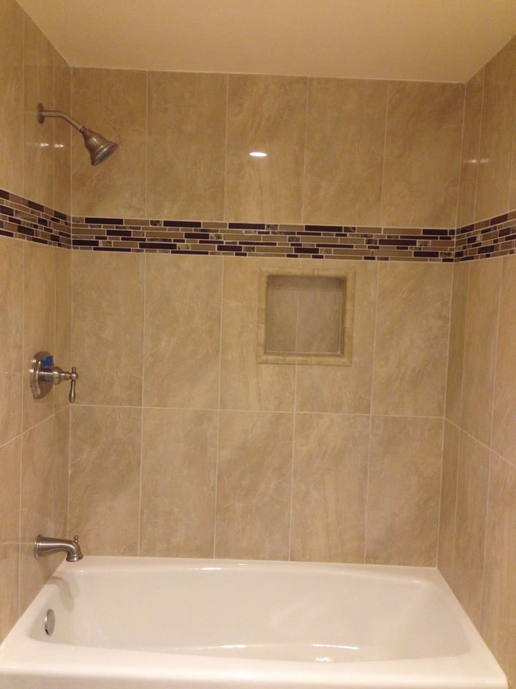 Klassisk inredning av ett mellanstort brun brunt badrum med dusch, med luckor med upphöjd panel, svarta skåp, ett badkar i en alkov, en dusch/badkar-kombination, en toalettstol med separat cisternkåpa, brun kakel, stenkakel, beige väggar, ett undermonterad handfat, granitbänkskiva och dusch med duschdraperi