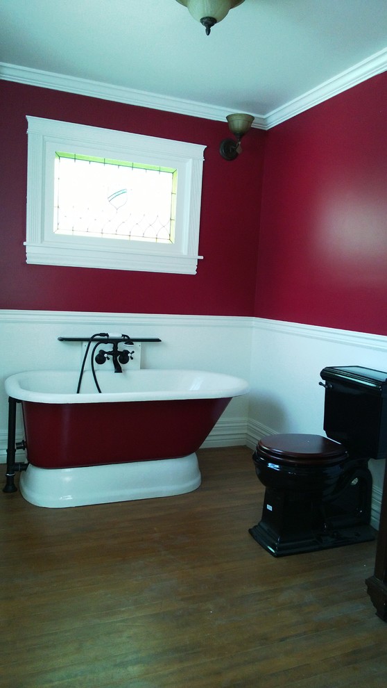 Esempio di una stanza da bagno con doccia american style di medie dimensioni con WC a due pezzi, ante in legno bruno, vasca freestanding, piastrelle nere, top in superficie solida, pareti rosse, parquet scuro e lavabo a bacinella