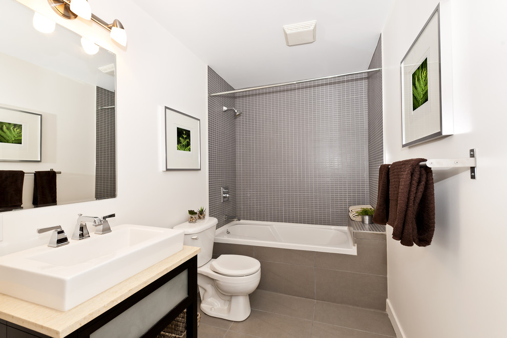 Пример оригинального дизайна: ванная комната среднего размера в современном стиле с плоскими фасадами, ванной в нише, душем над ванной, унитазом-моноблоком, коричневой плиткой, стеклянной плиткой, белыми стенами, полом из керамогранита, душевой кабиной, настольной раковиной, столешницей из известняка, коричневым полом и шторкой для ванной