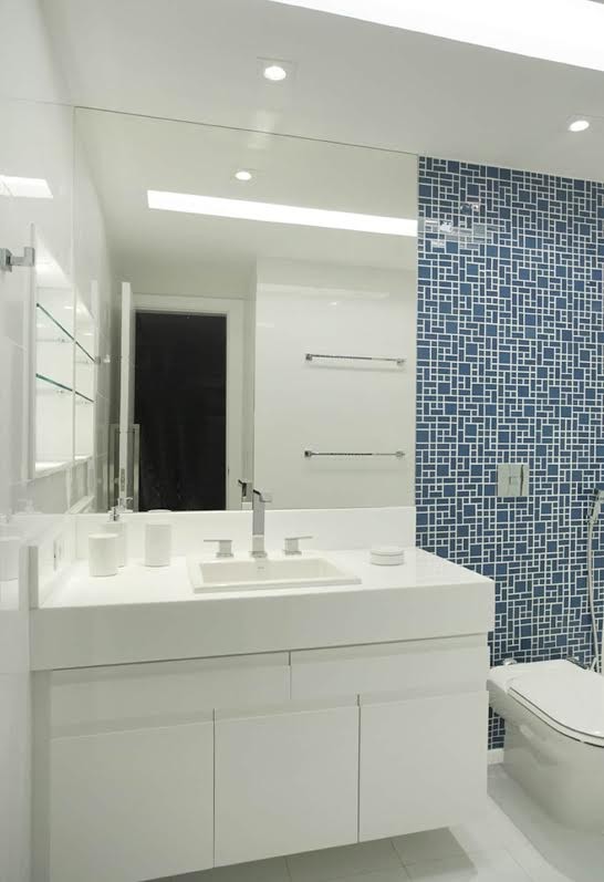 Immagine di una stanza da bagno con doccia classica di medie dimensioni con ante lisce, ante bianche, doccia alcova, WC sospeso, pareti bianche, pavimento con piastrelle in ceramica, lavabo da incasso, top in superficie solida, pavimento bianco e top bianco