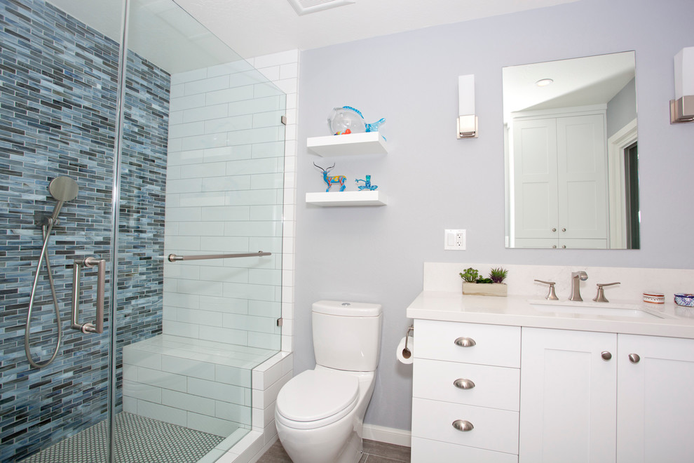 Mid-sized transitional master blue tile and glass sheet ceramic tile walk-in shower photo in San Francisco with flat-panel cabinets, white cabinets, a one-piece toilet, gray walls and an undermount sink
