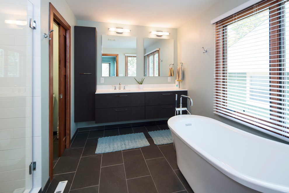Bathroom - modern subway tile slate floor and gray floor bathroom idea in Minneapolis with flat-panel cabinets, brown cabinets, gray walls, an integrated sink, solid surface countertops and a hinged shower door