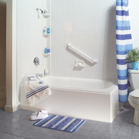 Cette photo montre une salle d'eau bord de mer de taille moyenne avec une baignoire d'angle, un combiné douche/baignoire, WC séparés, un carrelage blanc, des carreaux de céramique, un mur blanc, carreaux de ciment au sol, un sol gris et une cabine de douche avec un rideau.