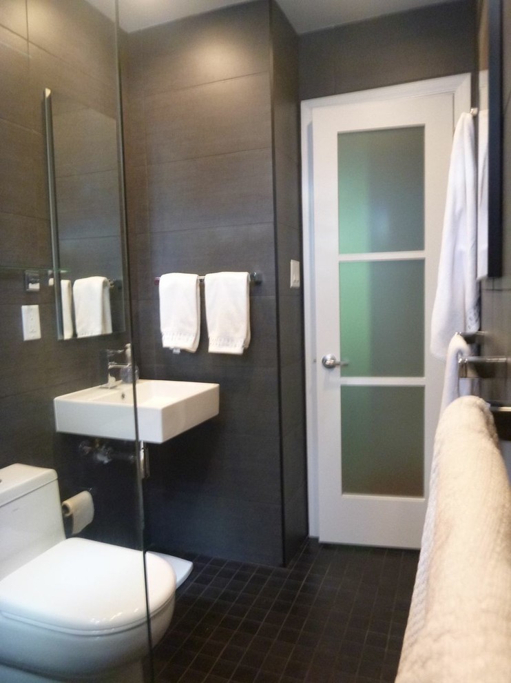 ミルウォーキーにある高級な中くらいなトラディショナルスタイルのおしゃれなバスルーム (浴槽なし) (壁付け型シンク、アルコーブ型シャワー、一体型トイレ	、黒いタイル、セメントタイル、グレーの壁、セラミックタイルの床、黒い床、オープンシャワー) の写真