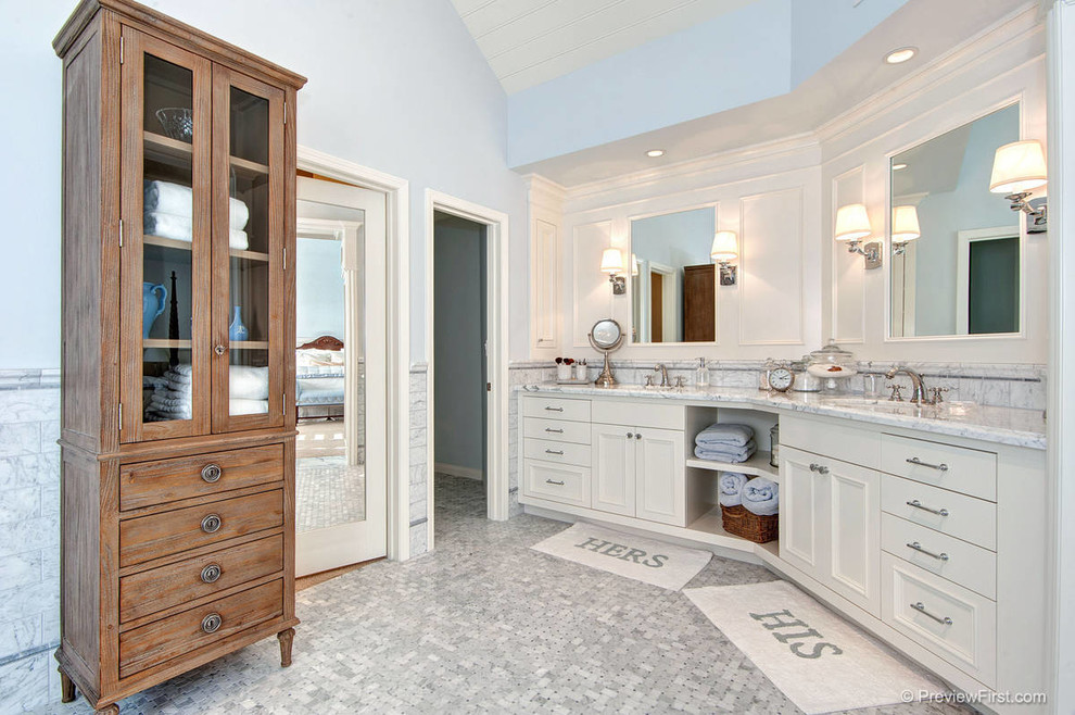Imagen de cuarto de baño marinero con puertas de armario blancas, encimera de mármol, bañera exenta, ducha esquinera y lavabo bajoencimera