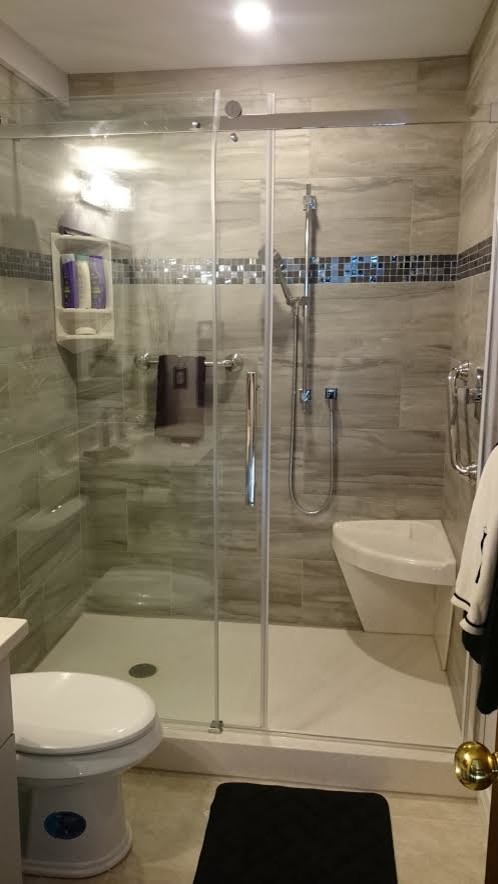 Medium sized traditional bathroom in Toronto with flat-panel cabinets, grey cabinets, an alcove shower, grey tiles, porcelain tiles, grey walls, ceramic flooring, a submerged sink and solid surface worktops.