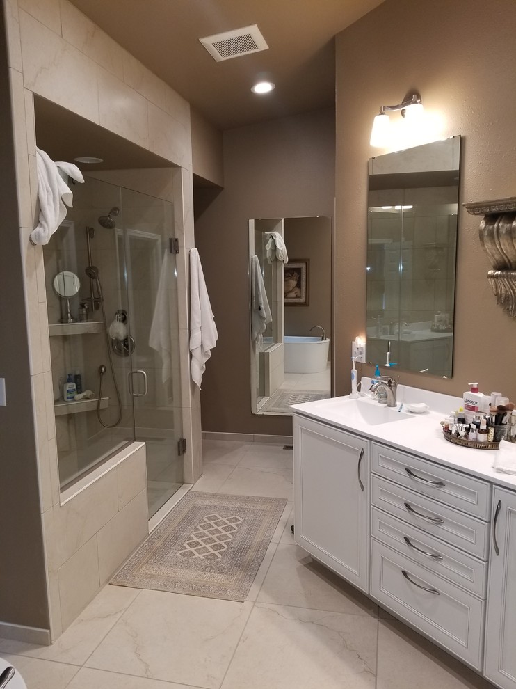 Example of a large classic master beige tile and porcelain tile porcelain tile and beige floor bathroom design in Cedar Rapids with beaded inset cabinets, white cabinets, a two-piece toilet, brown walls, a console sink, quartz countertops, a hinged shower door and white countertops