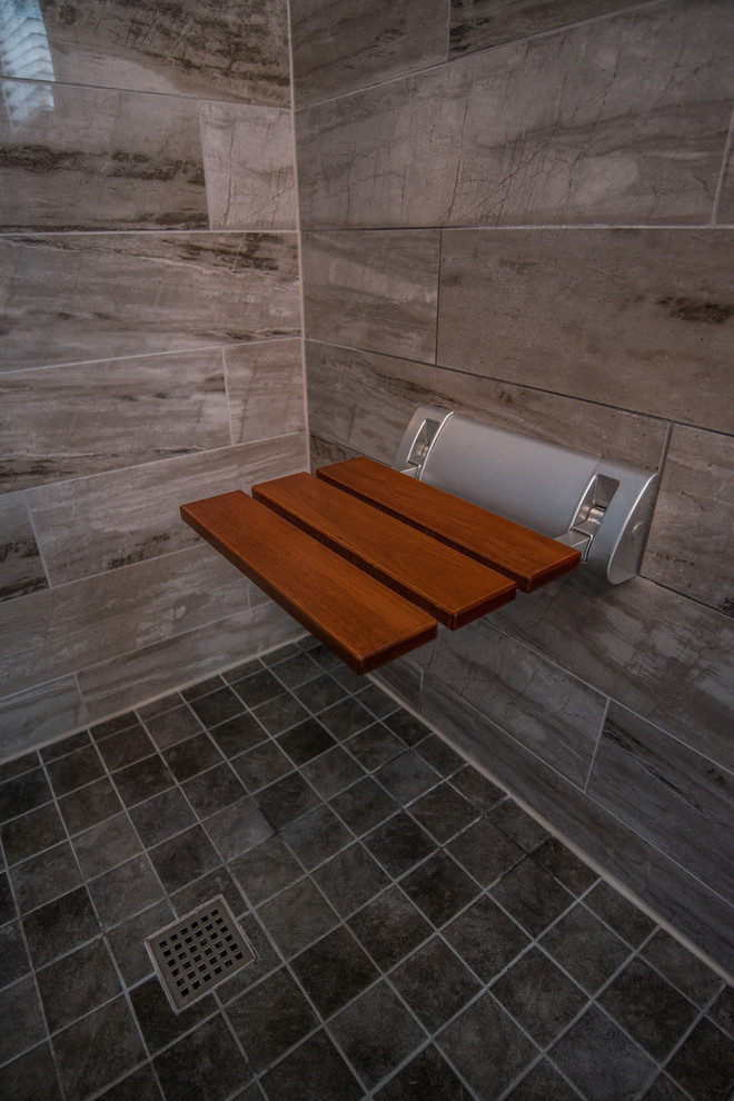 Klassisk inredning av ett litet en-suite badrum, med luckor med infälld panel, grå skåp, en dusch i en alkov, en toalettstol med hel cisternkåpa, beige kakel, marmorkakel, grå väggar, ett nedsänkt handfat, granitbänkskiva och dusch med gångjärnsdörr