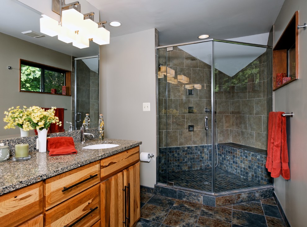 Foto de cuarto de baño tradicional con armarios con paneles lisos, puertas de armario de madera clara, ducha esquinera, paredes grises y lavabo bajoencimera