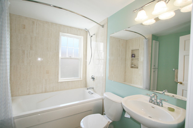 На фото: маленькая ванная комната в стиле неоклассика (современная классика) с ванной в нише, душем над ванной, раздельным унитазом, бежевой плиткой, керамогранитной плиткой, синими стенами, душевой кабиной, раковиной с пьедесталом и шторкой для ванной для на участке и в саду