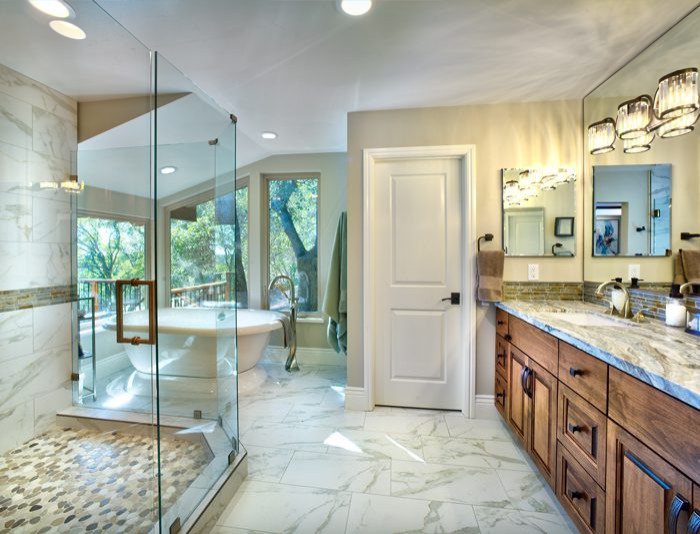 Источник вдохновения для домашнего уюта: большая главная ванная комната в классическом стиле с отдельно стоящей ванной, душем в нише, душем с распашными дверями, серой столешницей, фасадами с выступающей филенкой, фасадами цвета дерева среднего тона, бежевой плиткой, коричневой плиткой, серой плиткой, удлиненной плиткой, бежевыми стенами, мраморным полом, врезной раковиной, столешницей из гранита, белым полом, тумбой под две раковины и встроенной тумбой